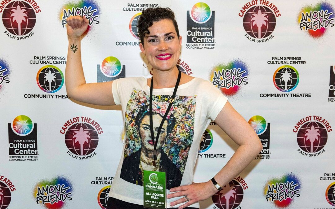 a female filmmaker with short dark hair smiles on a red carpet